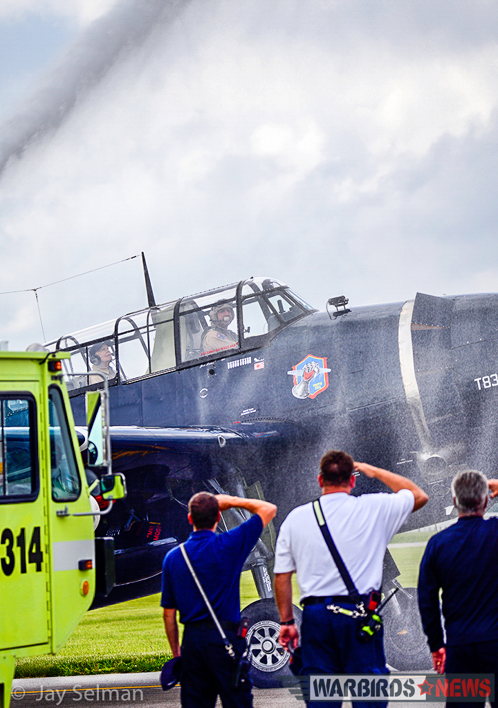Turkey Wrestling - Flying the TBM Avenger 14 WWII TBM Radioman/Gunner, Virgil Bloomquist (age 96) and Brad Deckert taxiing through a water-cannon salute after Virgil's first TBM flight in over 70 years. (Photo by Jay Selman)