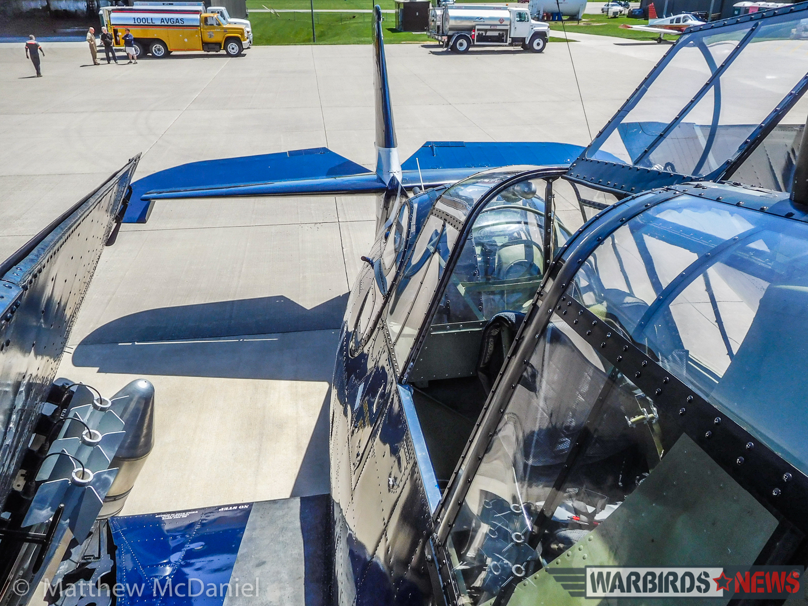 Turkey Wrestling - Flying the TBM Avenger 12 The view from atop the TBM's folded wings. The co-pilot's canopy hatch is open and the rockets and radar pod can be seen on the left. Behind, 11,000 gallons of avgas await the kickoff of the 2017 TBM Gathering. (Photo by Matthew McDaniel)