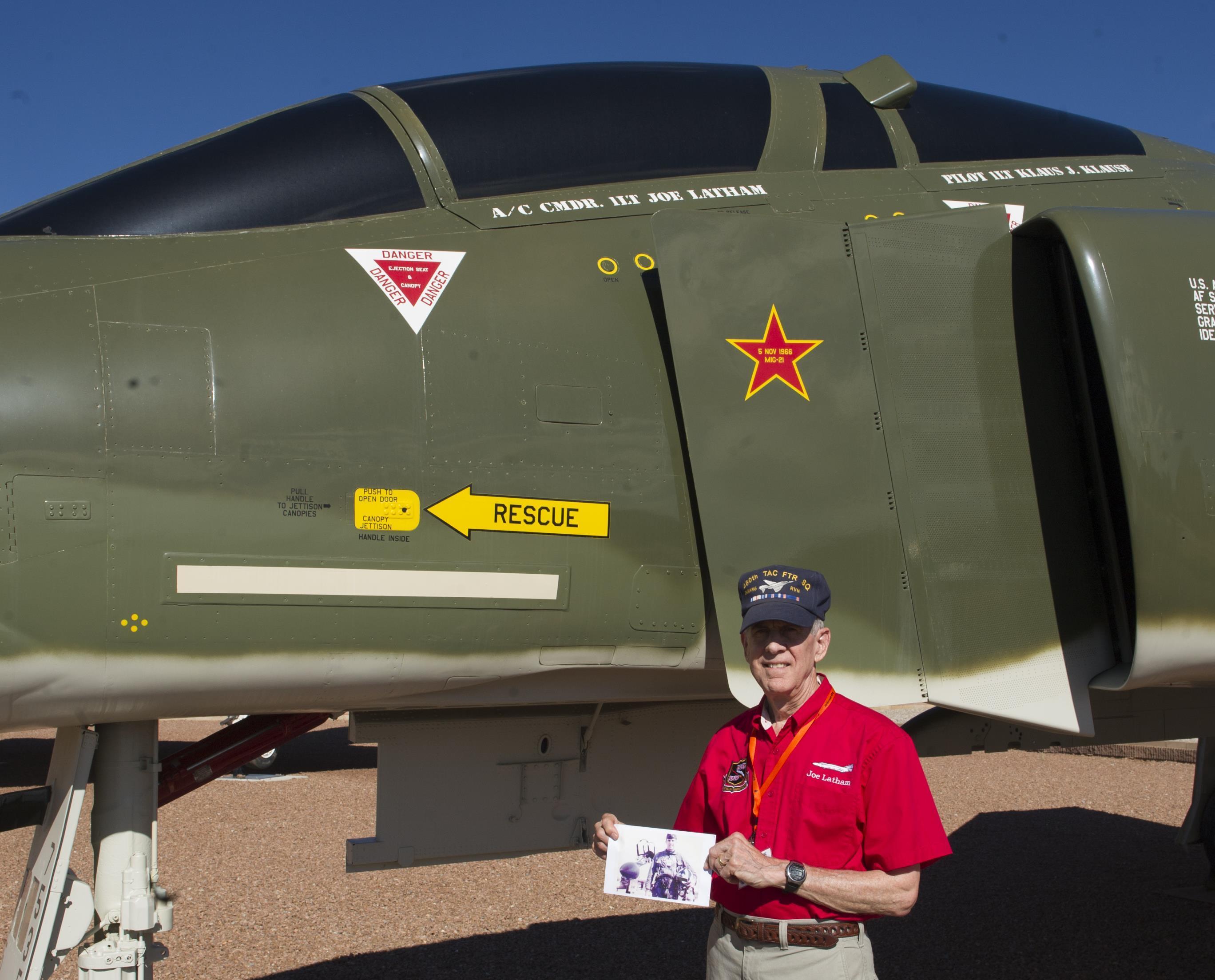 F-4 Pilot, MiG-21 Destroyer, Tells Story 11 Col. (Ret.) Joe Latham, previously an F-4 Phantom pilot from Holloman Air Force Base, N.M., poses for a picture with an old photo as a first lieutenant in 1966, next to an F-4 adorned with his name Sept. 13, 2016, at Heritage Park, Holloman AFB. Latham’s visit was part of the annual Phantom Society Tour where 160 aircraft enthusiasts, including veterans and non-veterans with aviation backgrounds, toured The tour included an F-16 Fighting Falcon static display and briefing, travel to Holloman’s High Speed Test Track, the opportunity to view QF-4 Phantom IIs and F-16s in flight, and a visit to the base’s heritage park to view static displays of various aircraft historically stationed at Holloman AFB. (U.S. Air Force photo/Master Sgt. Matthew McGovern)