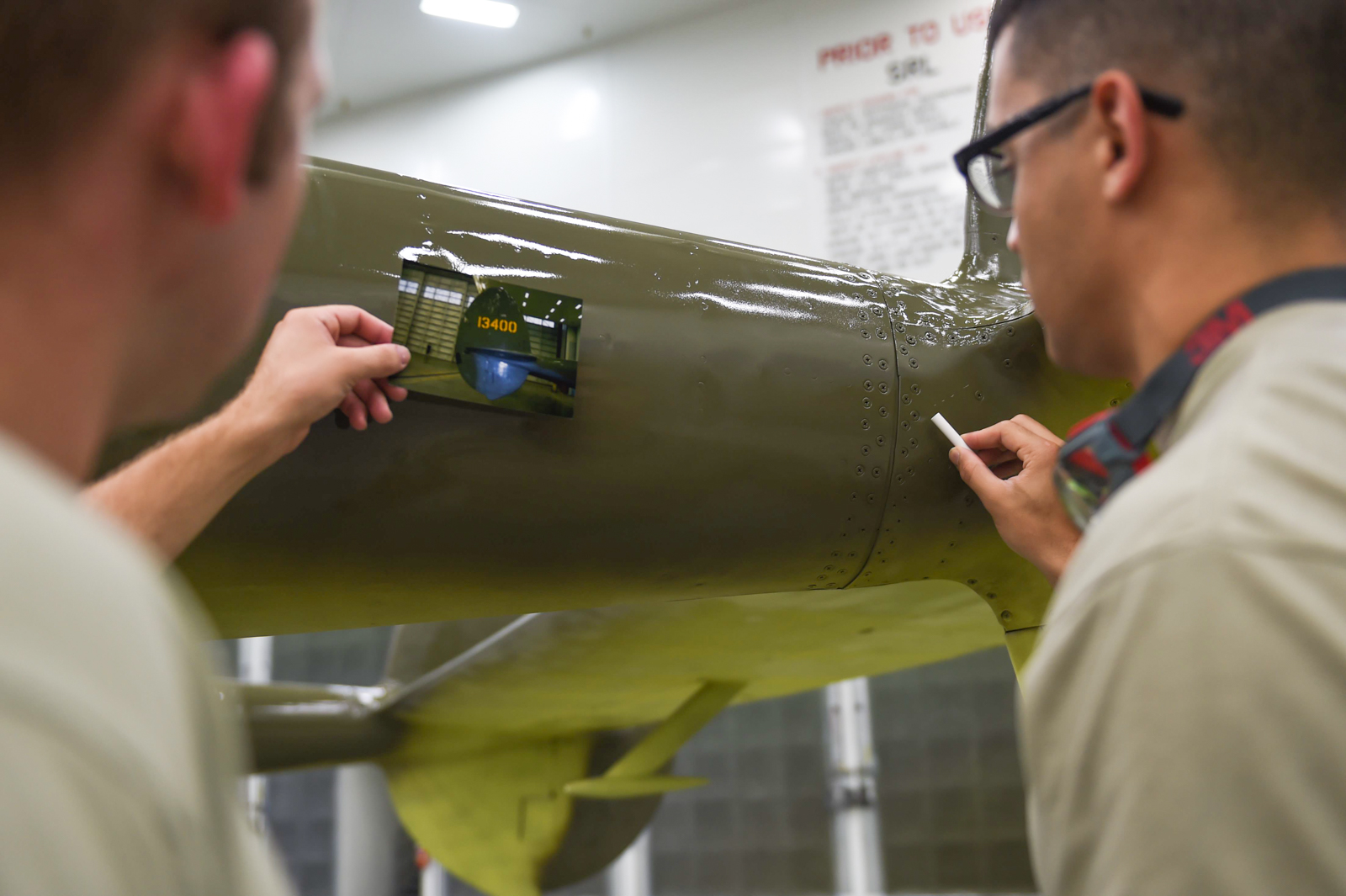 P-38G Lightning Under Refurbishment in Alaska 12 Air Force Senior Airman Kurtis Steinecke (left) and Airman 1st Class Jonathan Torres-Zaya put the final touches on the P-38G Lightning before it can be returned to the Heritage Park at Joint Base Elmendorf-Richardson, Alaska, July 20, 2017. (Photo by Staff Sgt. Sheila deVera)