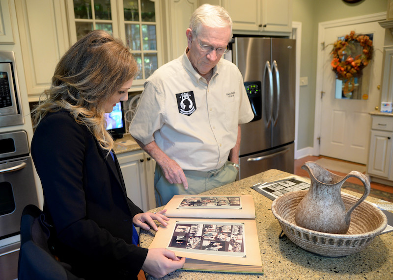 POW Recalls Mission That Led to Capture 50 Years Ago 14 Retired Lt. Col. Richard “Gene” Smith, former 50th Flying Training Squadron Commander, shows Courtney Cox, editor of Town and Gown magazine, documents and photos of when he was a prisoner of war, Oct. 17, 2017, in his home in West Point, Mississippi. Smith was shot down Oct. 25, 1967, and spent five and a half years as a POW. (U.S Air Force photo by Airman 1st Class Beaux Hebert)