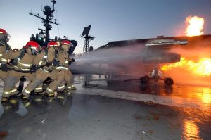 Some of the Most Important Planes on US Navy Carriers Never Fly 23 A repair locker hose team aboard USS John F. Kennedy (CV 67) combats a controlled fire on the MAFTD. (Image Credit: US Navy)