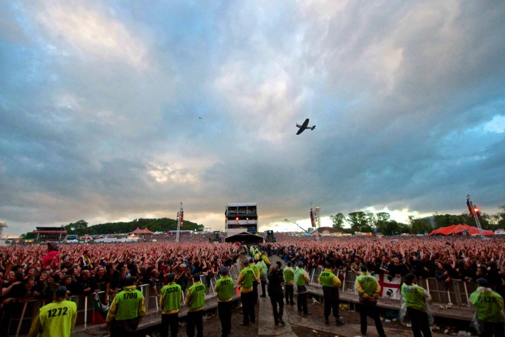 Aces High: A Heavy Metal Tribute to WWII Fighters 10 Spitfire TE311 of the RAF's Battle of Britain Memorial Flight performing a flyover for the crowd during Iron Maiden's June 15th concert at Donington Park, UK. (Image credit: Iron Maiden)