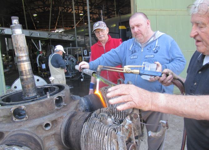 Australian Airspeed Oxford - Project Update 24 Volunteers working on one of the Oxford's engines. They are heating and cooling the cylinder barrel in an attempt to separate it from the engine core for servicing. (photo via B-24 Liberator Memorial Fund)