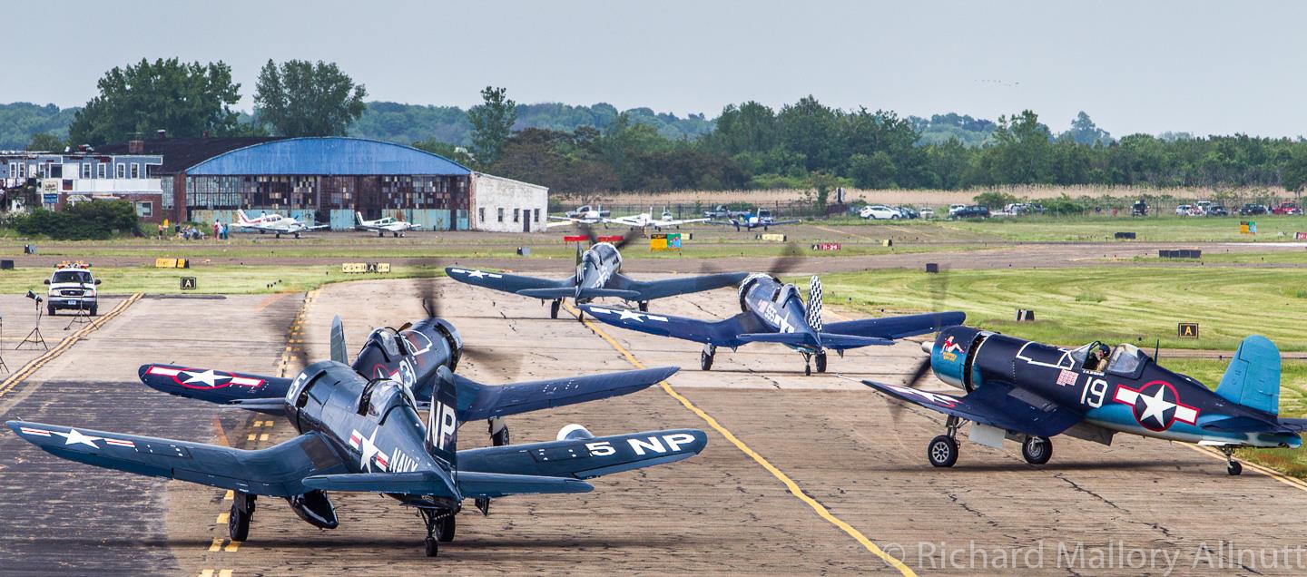 Curtiss Hangar Restoration Groundbreaking Ceremony 13 Corsairs taxiing during Corsairs Over Connecticut in 2010. The Curtiss Hangar is clearly visible in the distance. This scene is very reminiscent of similar images from the heyday of Corsair production during WWII. (photo by Richard Mallory Allnutt)