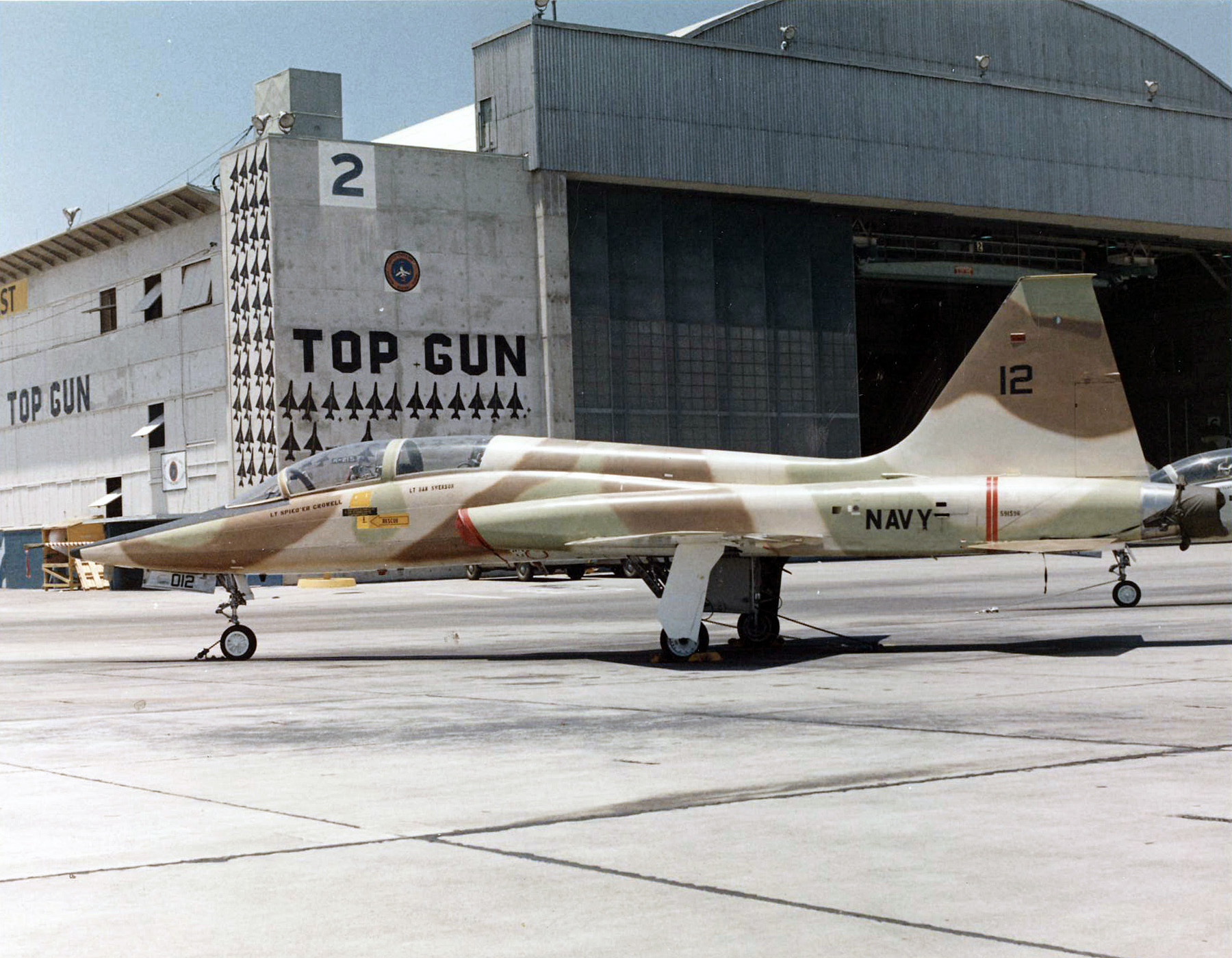 The Legacy of Top Gun 10 A T-38A Talon assigned to the Navy Fighter Weapons School pictured in front of the TOPGUN hangar on board Naval Air Station (NAS) Miramar, California, in 1974. The Talon was one of the aircraft types employed as an aggressor for training at the school. Note the silhouettes of MiG aircraft shot down during the Vietnam War painted on the hangar exterior. (Robert L. Lawson Photograph Collection, National Naval Aviation Museum)