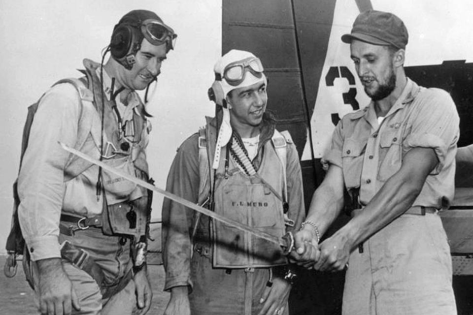 Yanks Air Museum’s Grumman F6F Hellcat Restoration 12 After fighting alongside Filippino guerillas Vraciu rejoined VF 20. Here he is shown displaying a Japanese officer s Katana sword to his squadron mates. National Naval Aviation Museum