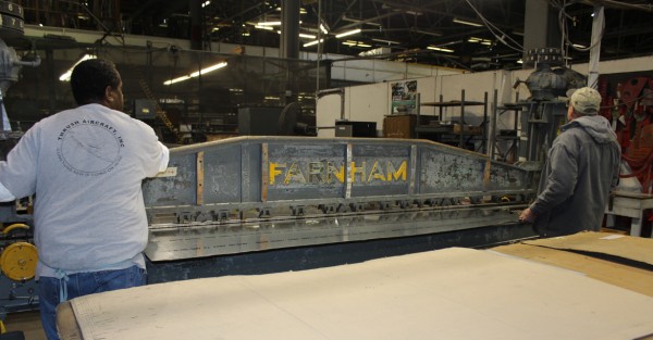 XP-82 Twin Mustang Restoration - February 2014 Update 14 Tom and a technician from Thrush Aircraft inserting the sheet metal for the left-hand leading edge skin into the Farnham roller. (photo via Tom Reilly)