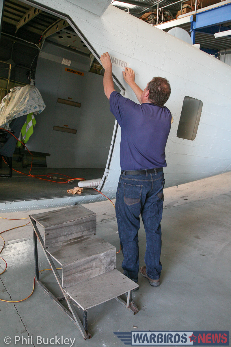 Twin Pioneer Restoration Update from Downunder 26 Richard Thompson applying the 'LIMITED' stencil to the fuselage near the cargo door. (photo by Phil Buckley)
