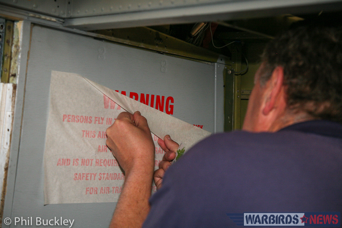 Twin Pioneer Restoration Update from Downunder 21 Richard Thompson applying the Warning decal inside the . (photo by Phil Buckley)