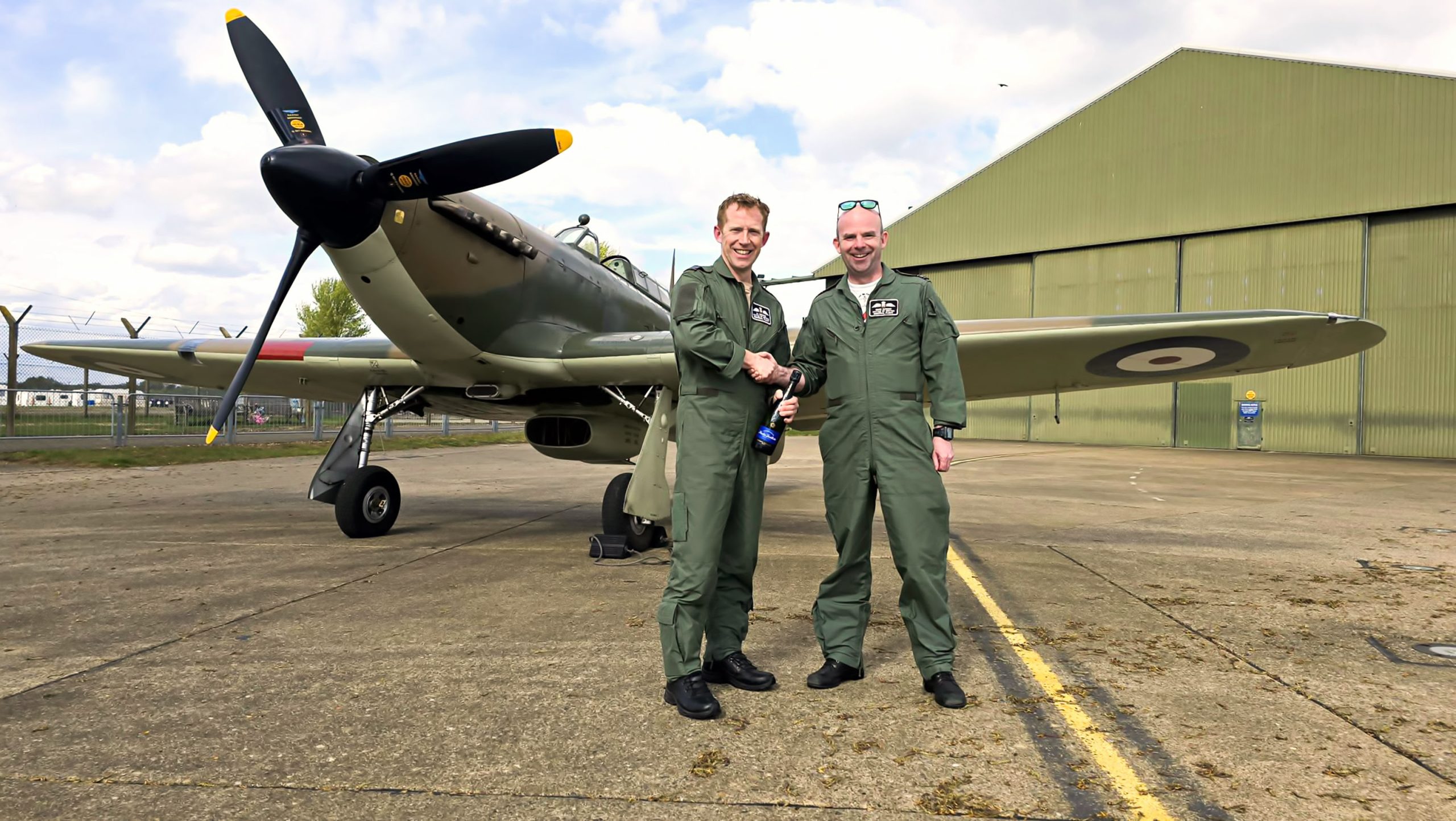 Battle of Britain Memorial Flight Members’ Day 2025 14 OC BBMF Sqn Ldr Mark ‘Suggs Sugden right congratulates Sqn Ldr Al Luckins left after his first flight in a Hurricane on 13th April with BBMF Hurricane Mk II LF363 behind them. Photo BBMF scaled