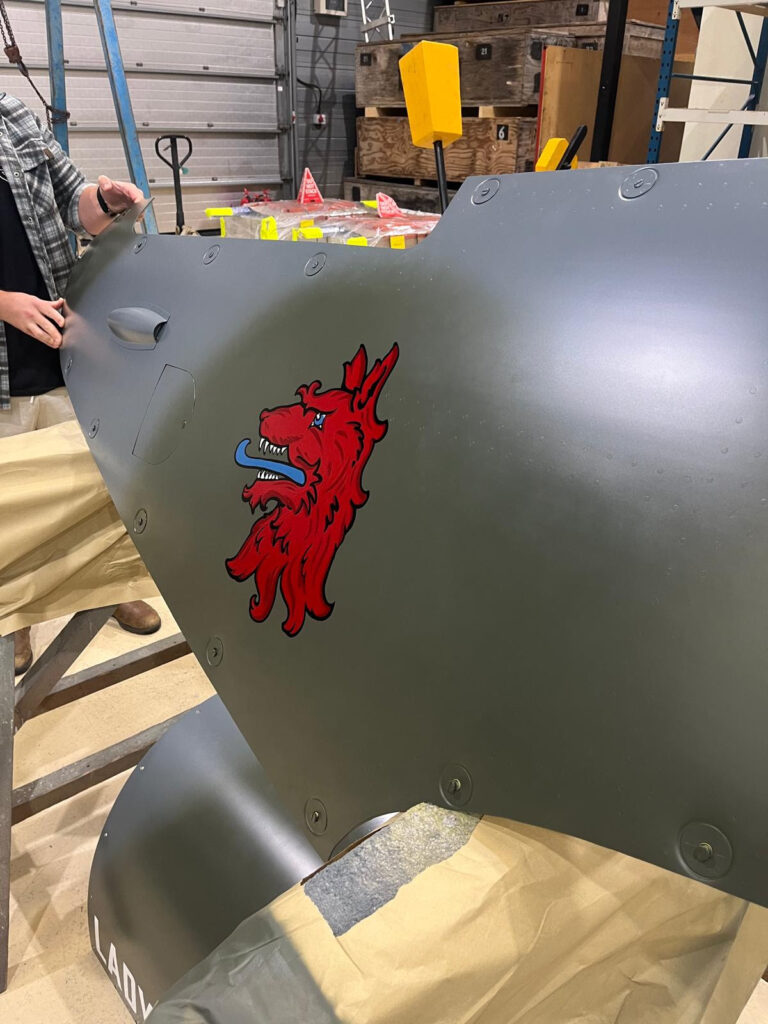 AeroLegends' MJ444 Special Event 11 One of the last tasks before MJ444s first post restoration flight was to add the 403 Squadron wolf nose art to the port engine cowling Photo Martin Overall