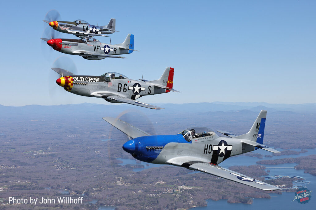 A Flight of Four Mustangs Celebrates WWII Fighter Pilot's 100th Birthday 10 TF-51 "E Pluribus Unum" piloted by owner Bob Bull with Paul Crawford in the back leads the formation over Lake Lanier. The camera ship was a Bonanza piloted by long time Liberty Foundation's pilot Cullen Underwood.