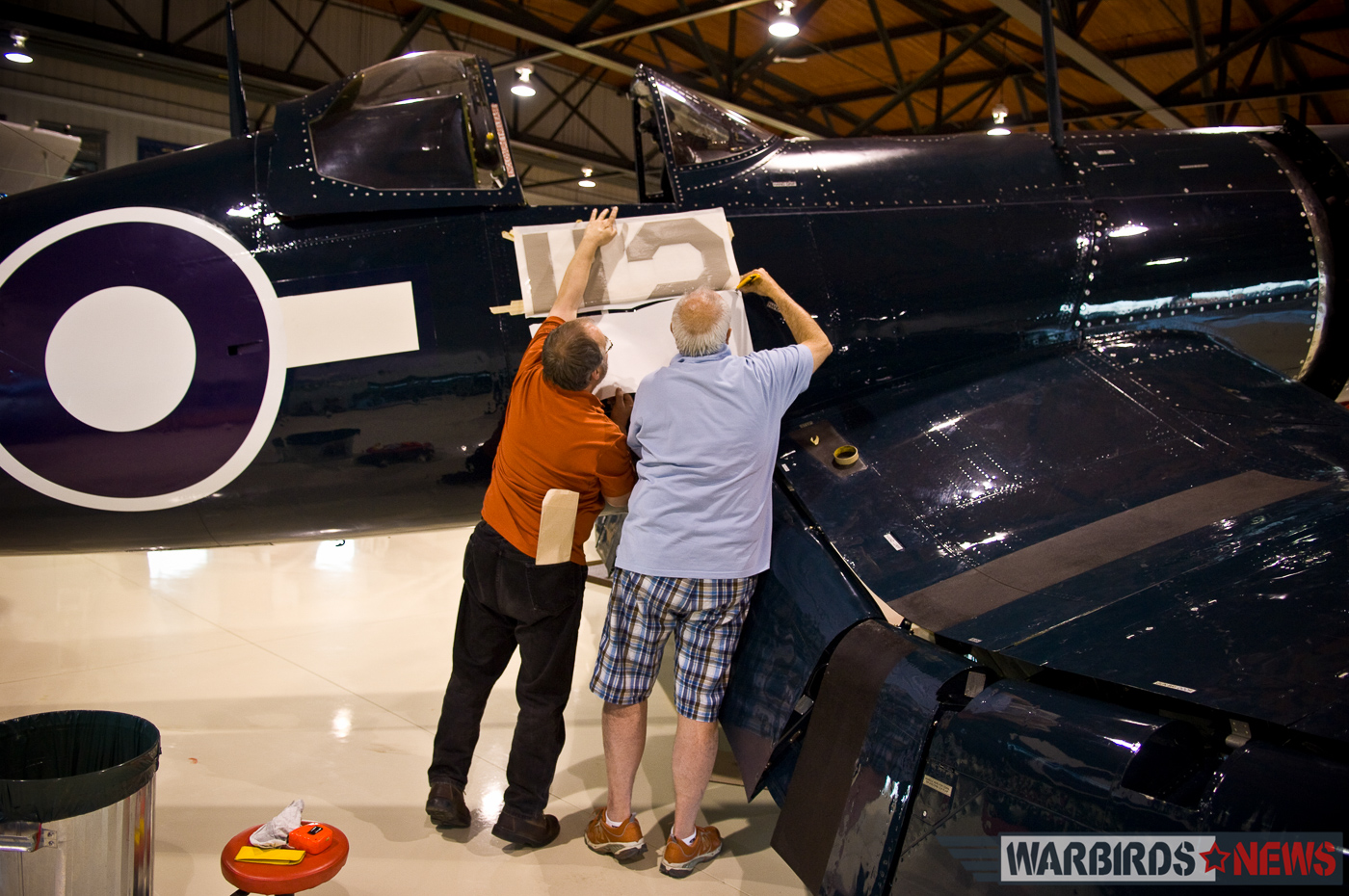 POOR LITTLE LAMBS - The Corsairs of Baa Baa Blacksheep 40 Dave O'Malley (right) and a colleague applying the decals to transform FG-1D Bu.92106 into Robert Hampton Gray's Corsair IV. (photo by Peter Handley)