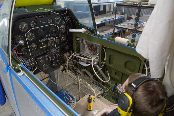 Texas Flying Legends P-51C Restoration Report 30 Aaron is looking over the job ahead of him. The yellow object in front of Aaron is a heat gun. (photo via AirCorps Aviation)