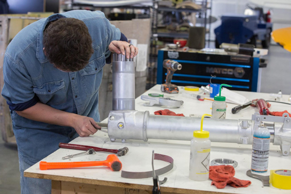 Texas Flying Legends P-51C Restoration Report 39 Clyde tightens a bolt on the pivot shaft end of the main gear. (photo via AirCorps Aviation)