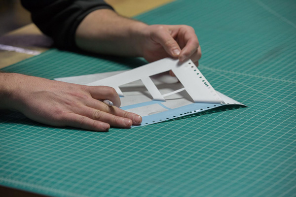 Texas Flying Legends P-51C Restoration Report 34 Max “weeds” or removes the areas that will receive paint from a vinyl mask created to paint the circuit breaker box cover. (photo via AirCorps Aviation)