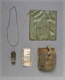 A VETERAN’S STORY: Coming Home - Part I 11 Remnants found at the crash site top left to bottom right dog tag chain fragment signal marker pouch match holder parachute survival guide and ammo pouch