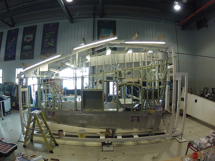 Vintage Wings of Canada's Spitfire Update 11 It has been five years since work on the wings began at Vintage Wings of Canada. Beneath those extraordinarily sublime and elegantly simple elliptical Spitfire wings ran a labyrinth of ribs, supports, straps, wells, access panels, bays, channels, spars and linkages—held in place by thousands of rivets, each part with specific requirements for gauge, strength and hardness of material. Wood's methodical and unhurried pace ensured that mistakes did not build upon each other, rendering weeks, months or even years of work scrap. To be in the company of Wood near his wing build throughout this period was to be in a sort of Zen-like zone where voices were lowered, decisions were made only after checks were made and remade, and where craftsmanship and quality of work became a fetish. ( Photo by Ken Wood from GoPro)