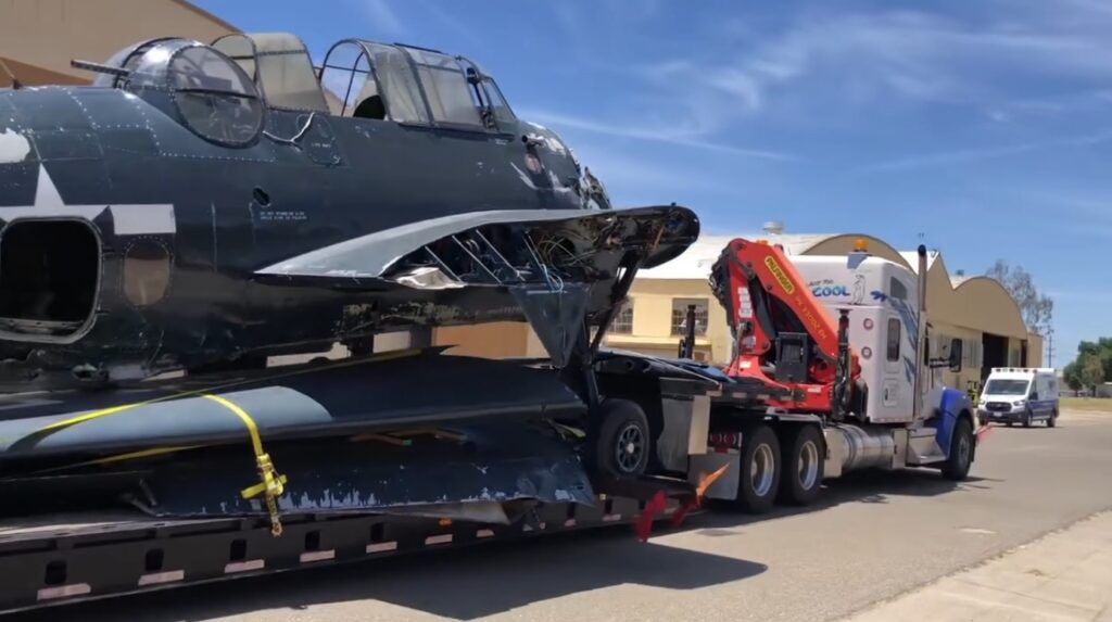 Castle Air Museum Receives Infamous TBM 16 Strapped to a flatbed trailer towed by Polar King International TBM Avenger 91188 arrives at the Castle Air Museum restoration hangar Castle Air Museum