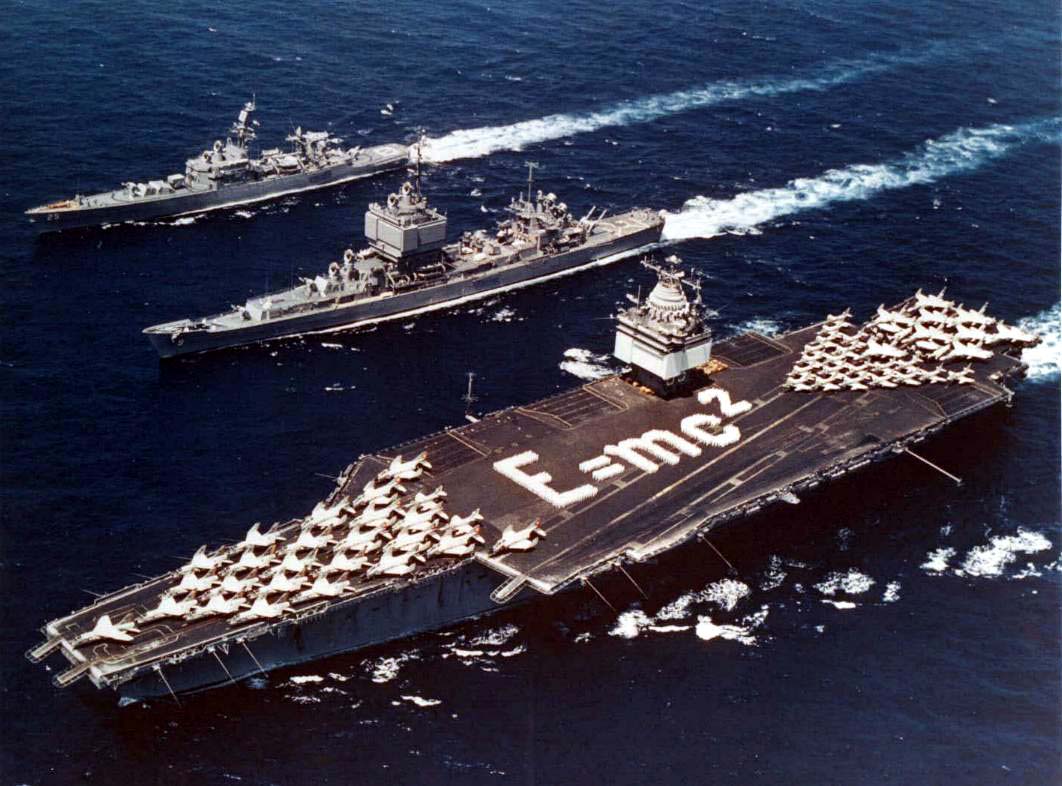 Final Farewell to USS Enterprise 12 Task Force 1, the world's first nuclear-powered task force. Enterprise, Long Beach and Bainbridge in formation in the Mediterranean, 18 June 1964. Enterprise has Einstein's mass–energy equivalence formula E=mc² spelled out on its flight deck. Note the distinctive phased array radars in the superstructures of Enterprise and Long Beach.