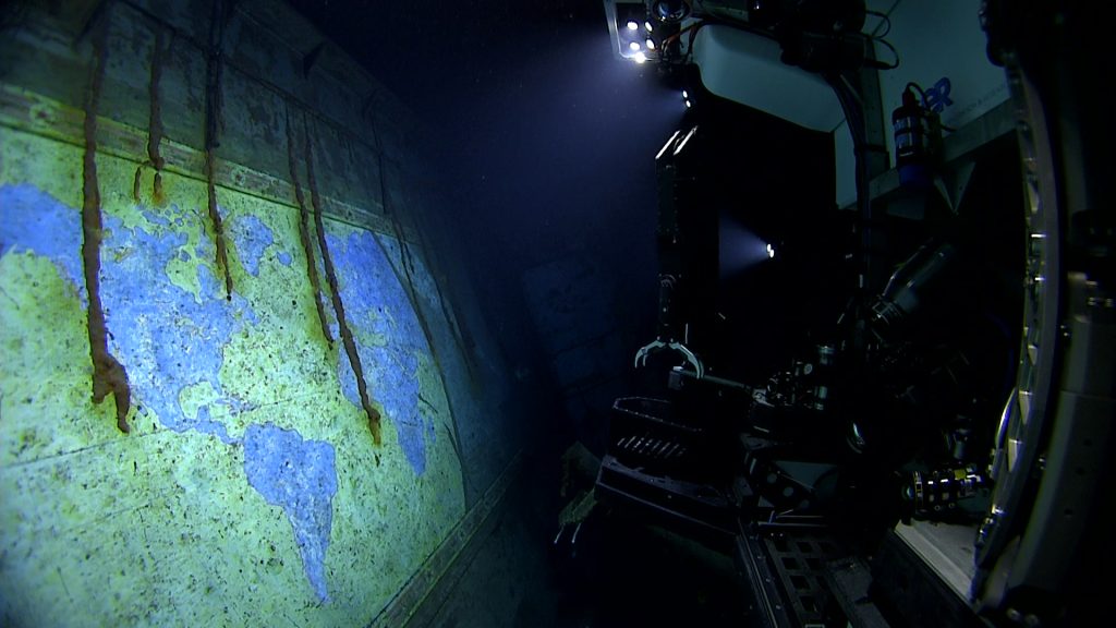USS Yorktown Rediscovered: 2025 Dives Reveal New Clues from the Battle of Midway 14 The lights of remotely operated vehicle Deep Discoverer illuminate the hand painted mural A Chart of the Cruises of the USS Yorktown during the ROV and Mapping expedition dive on Apr