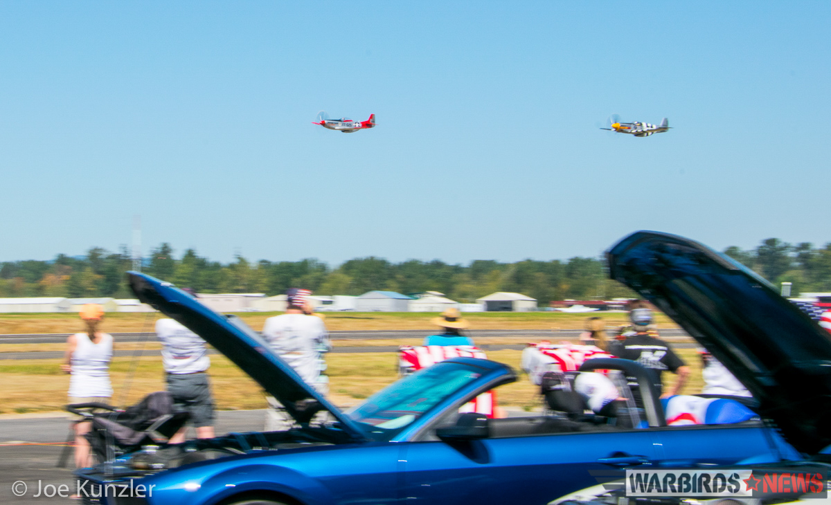 Props & Ponies at the Heritage Flight Museum - Air Show Report 31 The P-51s roaring past the assembled Ford Mustangs on the tarmac. (photo by Joe Kunzler)