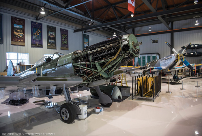 Vintage Wings of Canada's Spitfire Update 10 Two beautiful roses. The Roseland Spitfire, Y2-K (in background), now shares the hangar with Spitfire XVI (AU-J in foreground), once known in the warbird world as the Rose Garden Spitfire. Soon, they will fly together over Gatineau skies, telling the world of Canada's fighter heroes of the Second World War. Also in the hangar is the Robillard Brothers P-51 Mustang (Y2-C), also painted in the markings of 442 Squadron, which had converted to the Mustang by war's end. We will also see two 442 Squadron fighters together again for the first time since the days of the Canadair Sabre. ( Photo by Pter Handley)