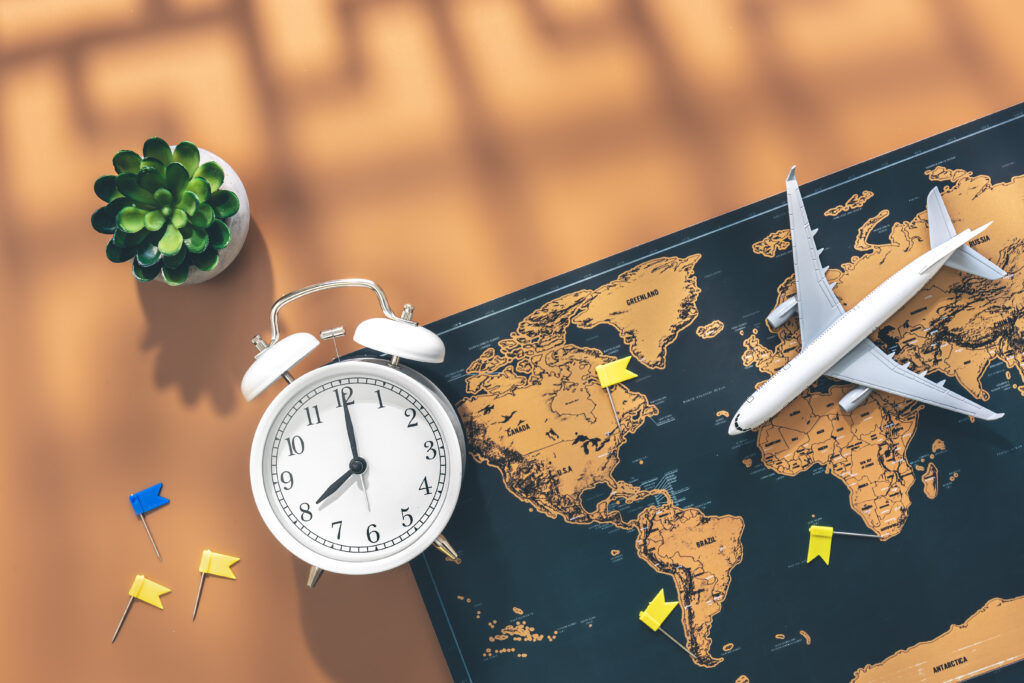The Impact of Aviation on Global Education 10 alarm clock airplane miniature world map brown background flat lay