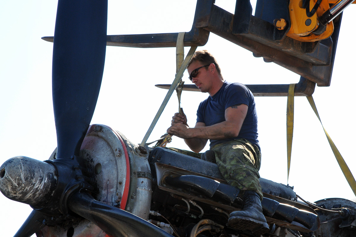 Lancaster KB882 Safely At Her New Home 17 An RCAF technician from ATESS tightens straps on one of KB882’s engines in preparation for its removal. (Photo by Warrant Officer Fran Gaudet DND)