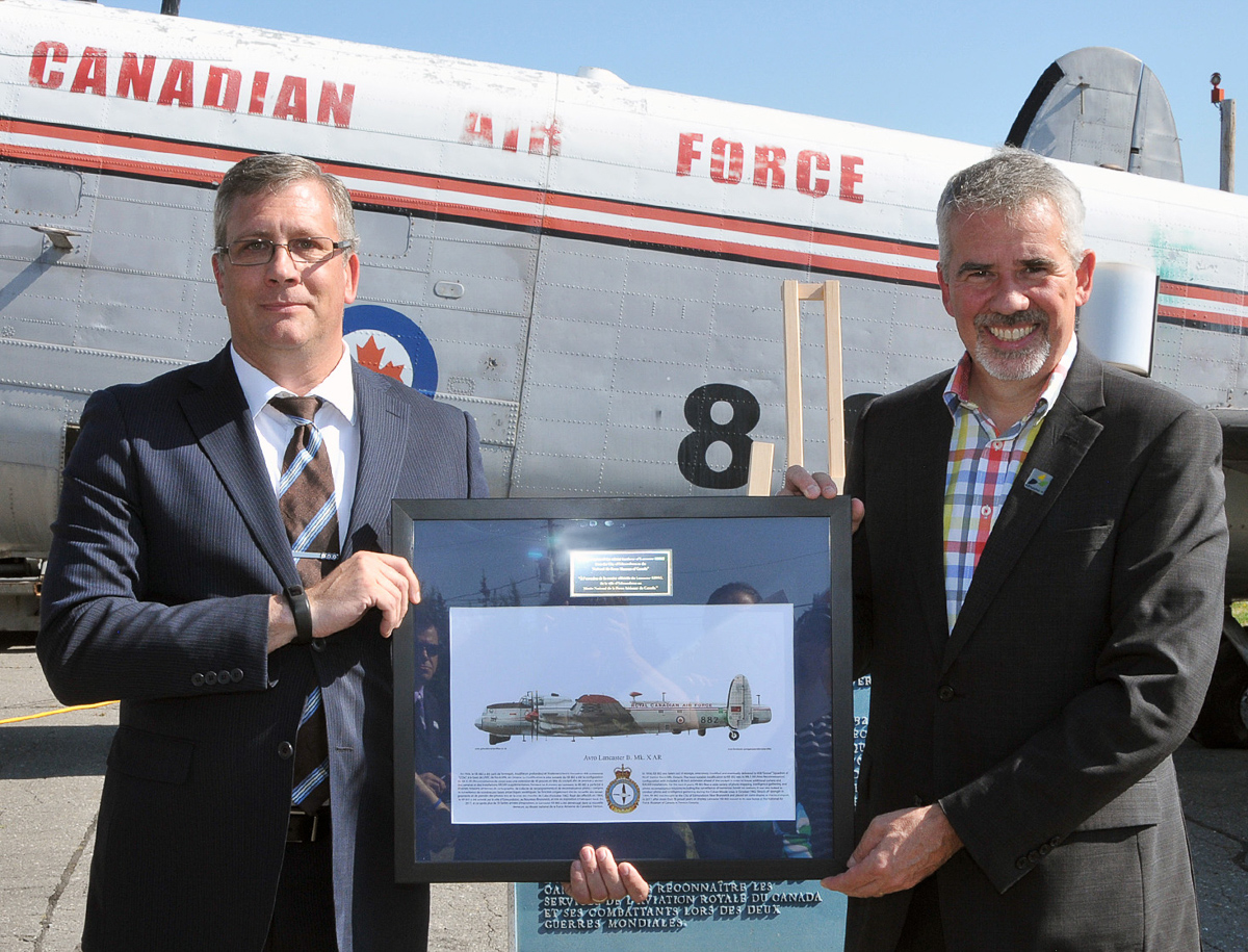 Lancaster KB882 Safely At Her New Home 15 The curator of the National Air Force Museum of Canada, Kevin Windsor (left), presents Edmundston mayor Cyrille Simard with an artist’s concept of how KB882 will appear following its restoration. (Photo by Warrant Officer Fran Gaudet DND)