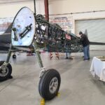The Stearman for the first time sees the light of the CAF Airbase Georgia's hangar. You can see the tail of the unit's SBD-5 Dauntless. [Photo by Angela Decker]