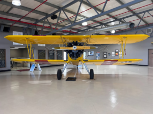 Head-on view of Stearman N555BF inside the Planes of Fame’s Edward T. Maloney Hangar. [Photo by Adam Estes]